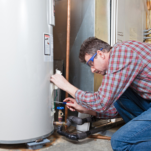 A plumber is performing maintenance on a residential water heater